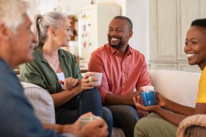 Friends sitting together in a home, talking and laughing together