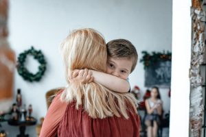 Blonde mother hugging son in comfort