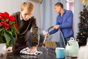 Father and teen son cleaning the house at Christmas