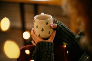 Woman sitting quietly, relaxing with a hot drink in a Christmas mug