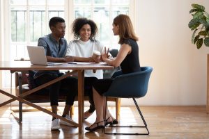 Couple sitting at table and discussing estate plan options with expert