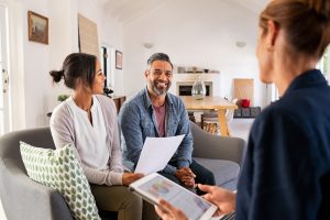 Couple sitting on couch and talking with representative about charitable gifts
