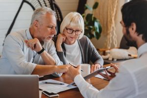 Mature couple looking at documents with an attorney in the comfort of their home