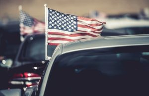 American flags waving from car window 
