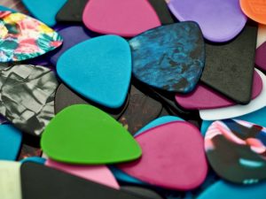 Pile of guitar picks in different colors.