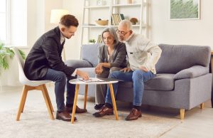 Mature couple sitting at home with attorney to discuss estate plan