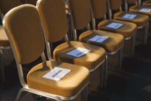 Tan chairs with white reserved signs in them.