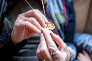Elderly woman wearing a memorial locket with a picture inside