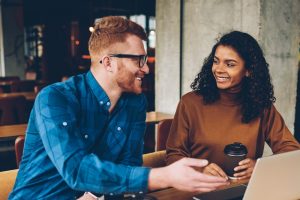 Two colleagues chatting with each other in front of a computer