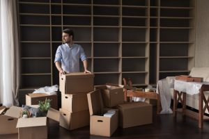 A man looking around after he's finished packing boxes