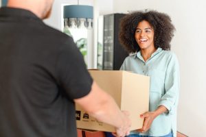 A woman handing a box over to another person