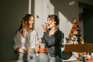 two women laughing over coffee