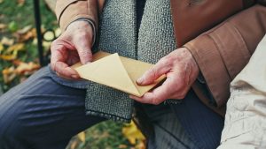 Close up of man's hands holding an envelope