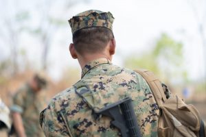 Marine carrying pack and walking with comrades