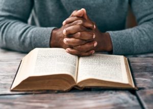 Man resting hands on an open Bible