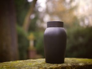 black urn placed in a wooded area