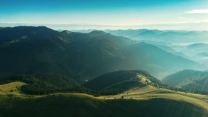green hills with misty clouds at sunrise