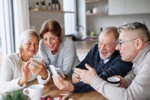 Older friends sharing photos on their phones