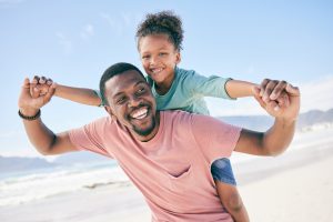 AA image- father and daughter playing on a beach and laughing