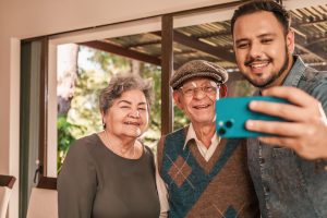 A man taking a selfie with his elderly relatives