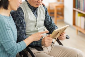 Close up of a man holding a picture frame and a woman pointing to it.