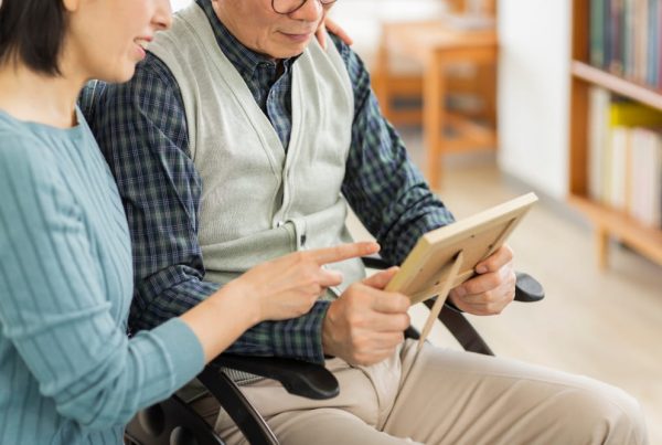 Close up of a man holding a picture frame and a woman pointing to it.