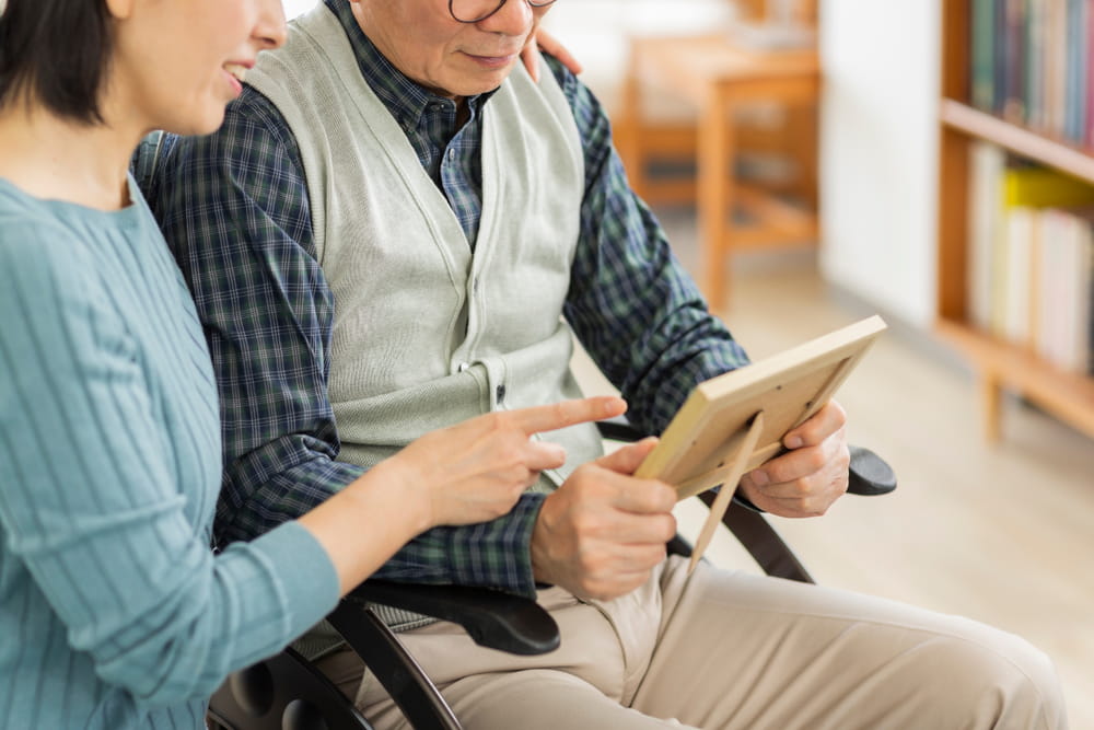 Close up of a man holding a picture frame and a woman pointing to it.