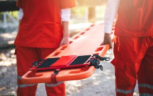 Close up of people carrying an empty stretcher.