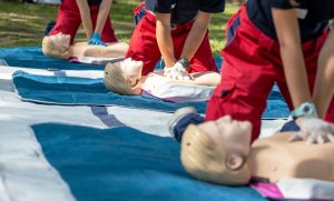 Close up of people doing CPR on dummies.