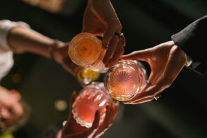 a group of friends making a toast, looking up at the bottom of the glasses