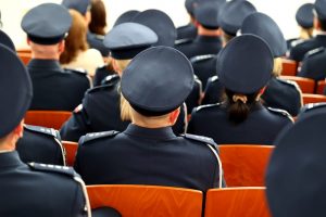 Police officers sitting together in chairs, from behind.