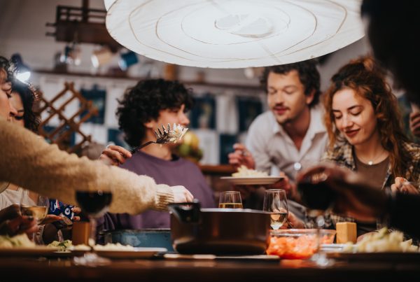 friends serving each other dinner at a large table