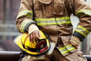 Close up of firefighter holding helmet.