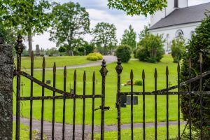 looking through a cemetery gate towards the cemetery and church