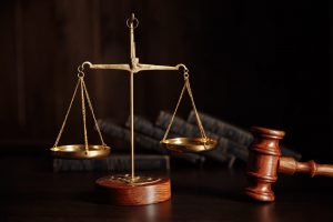 Justice scale and gavel against a backdrop of books
