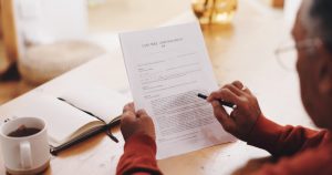Man sitting at table, reviewing his last will and testament