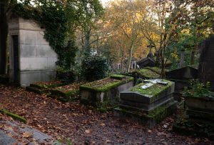 mausoleum in a cemetery surrounded by tress and greenery