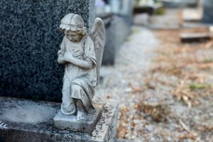 angel statue kneeling on a headstone