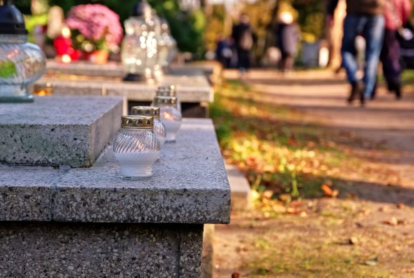 lanterns placed on a headstone and people walking in the background
