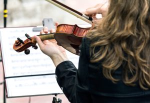 A woman playing the violin and reading sheet music