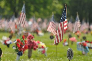 small flags and flowers at a veterans cemetery