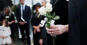 Grieving loved ones holding white roses
