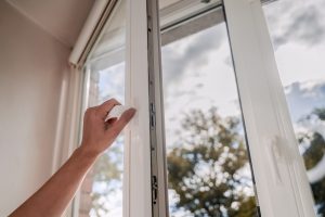 A person opening a window