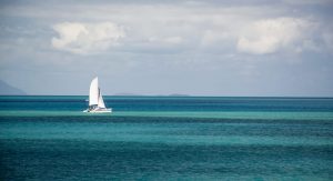 Sailboat in the distance against the turquoise waters of the ocean