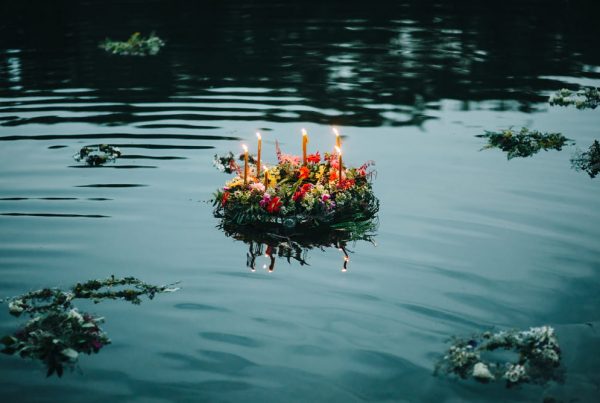 Wreath of flowers and candles floating on the surface of a lake